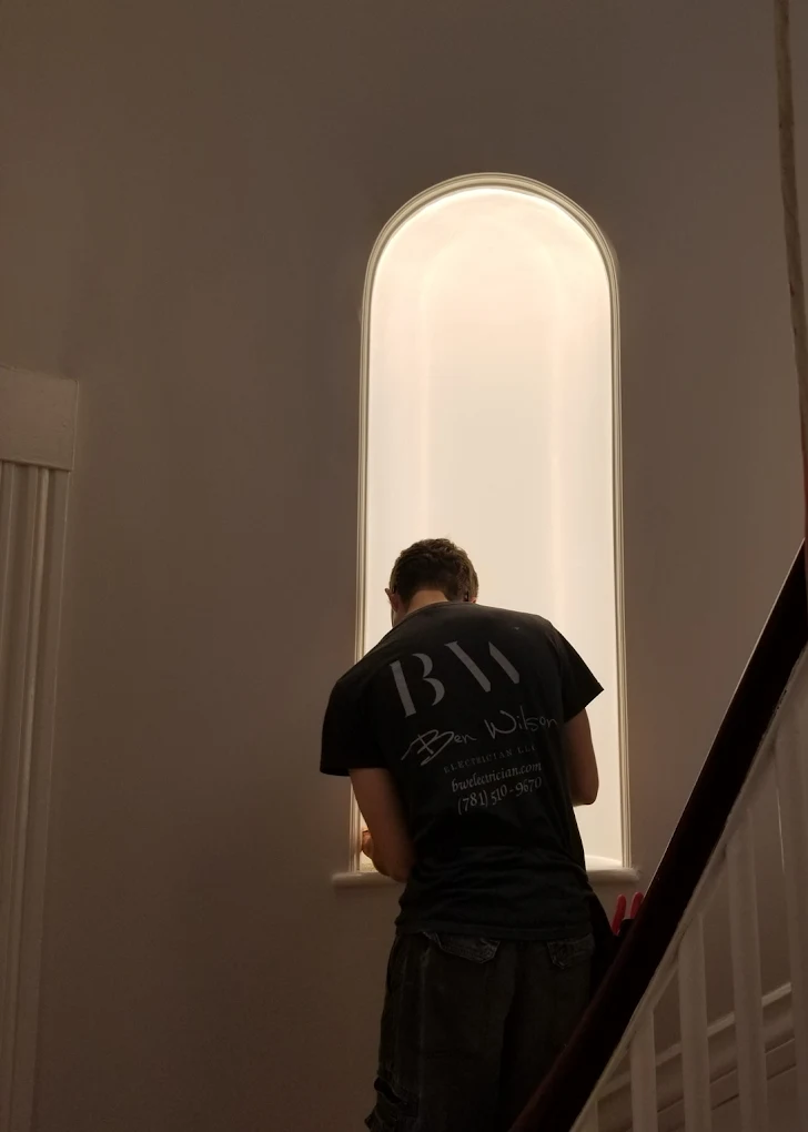 Ben Wilson of BW Electrical Contractors installing lighting in an arched stairwell window niche